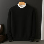 Black knitted jumper on a wooden hanger, layered over a white collared shirt, front view