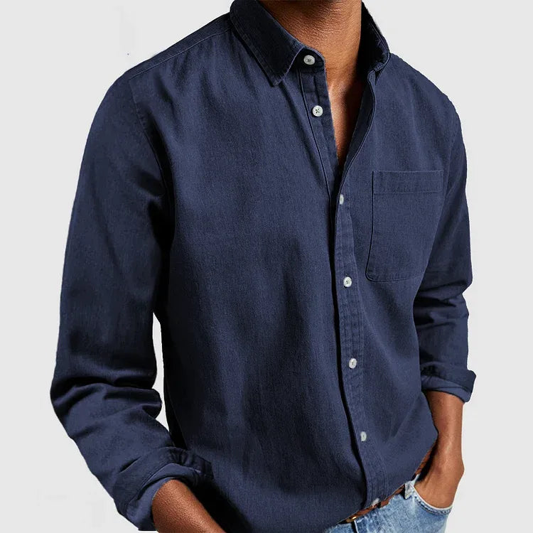 Front view of a man wearing a navy blue denim-style long sleeve shirt with chest pocket and button-down collar