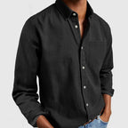 Black long sleeve button-up shirt worn open at the collar, showing the relaxed fit through the torso