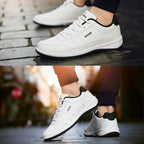 Two angled views of white leather trainers with black heel tab worn on foot showing cushioned sole and stitch detailing