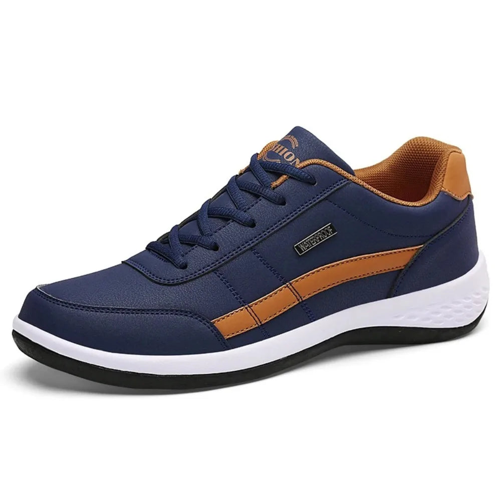 Product shot on white background of navy leather trainer with tan trim, white sole and black outsole