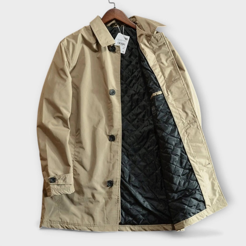 Side view of a beige trench coat on a wooden hanger, showing the black diamond-quilted inner lining