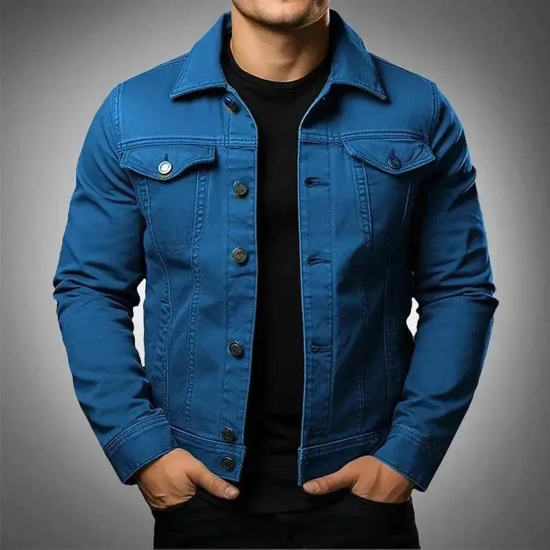 Blue denim trucker jacket with chest flap pockets and button fastening, worn over a black t-shirt