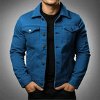 Blue denim trucker jacket worn open over a black t-shirt, front view showing sleeve and cuff