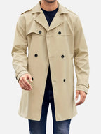 Man wearing a beige double-breasted trench coat open over a navy jumper, front view showing notched lapel and buttons