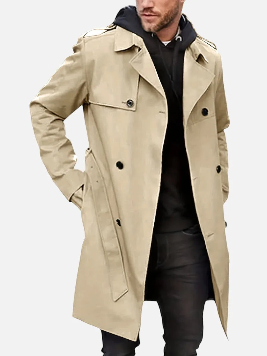 Beige trench coat worn open over a black hoodie, front view highlighting shoulder epaulettes and pocket flap