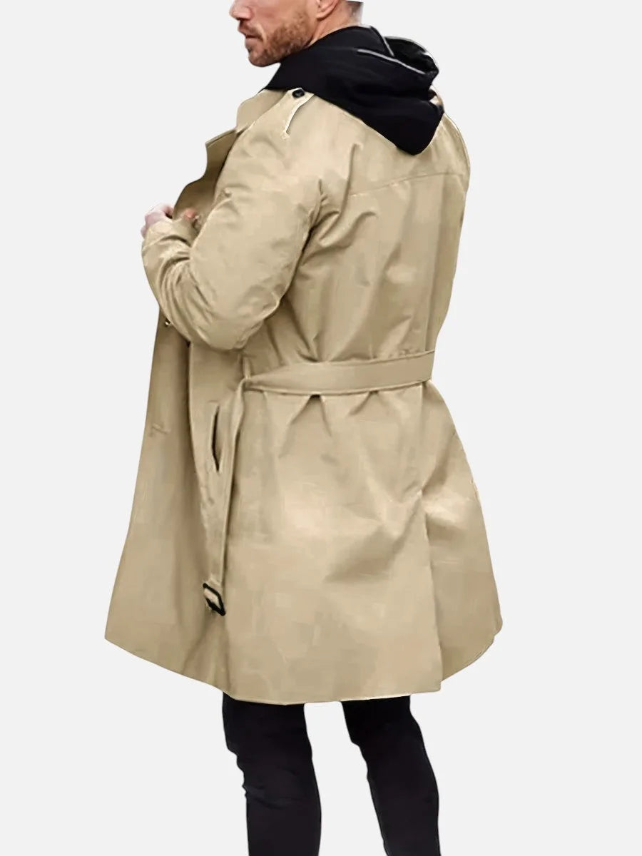 Side rear view of the beige trench coat worn with the hood of a layered top, showing belt and epaulette