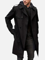 Black double-breasted trench coat worn over a dark hoodie, front view showing tie belt at the waist