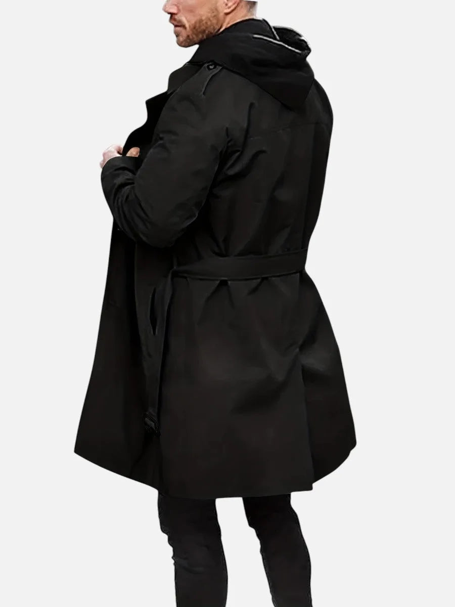 Rear view of the black trench coat with hood layered underneath, showing shoulder and back panel detail