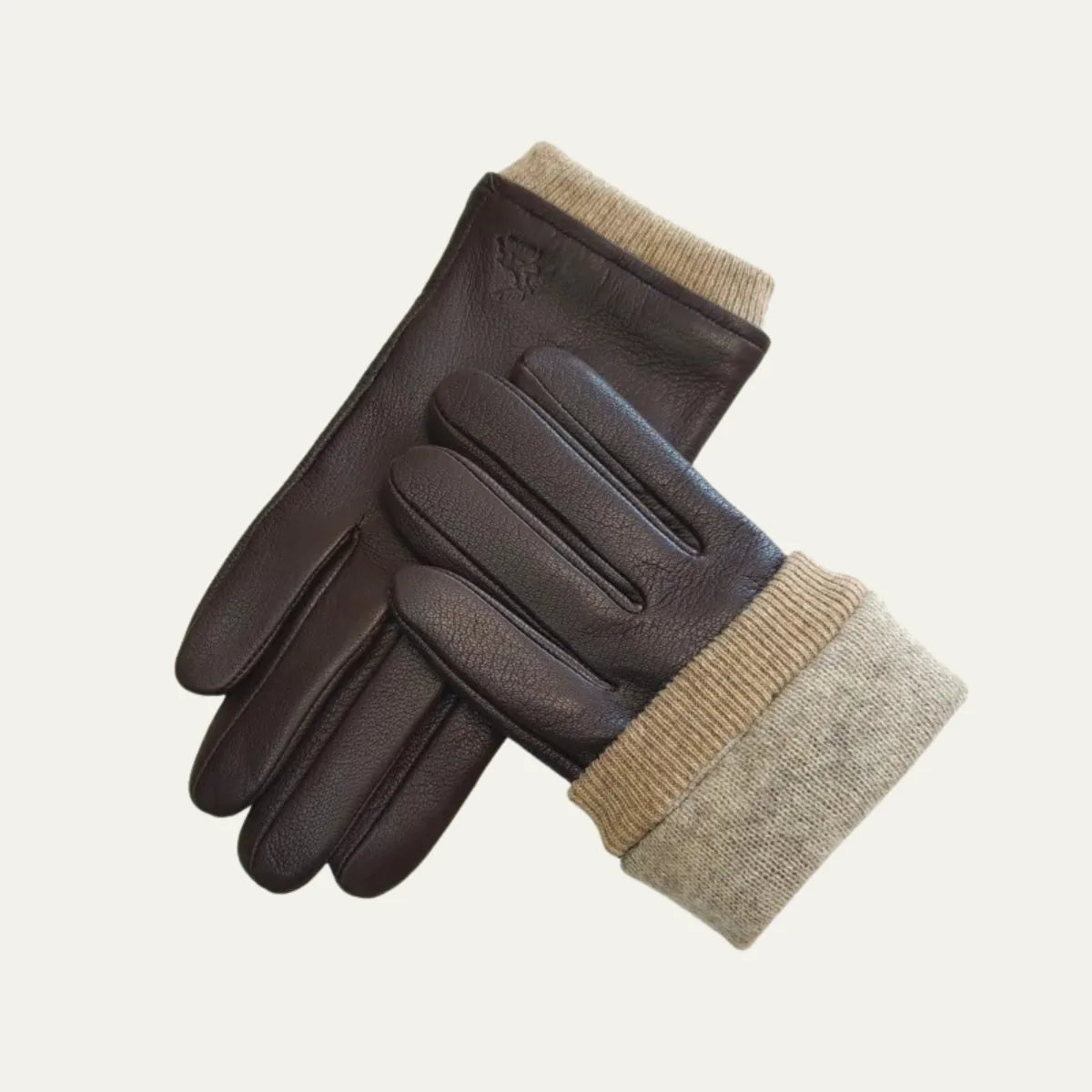 Brown leather gloves laid diagonally with the beige knitted cuff folded down to reveal its full length