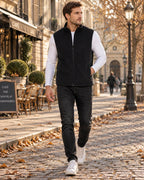Black fleece gilet with high collar and full zip, paired with a white top, dark jeans and white trainers