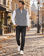 Grey fleece gilet with full zip and zipped pockets, shown with white top and faded black jeans on cobblestones