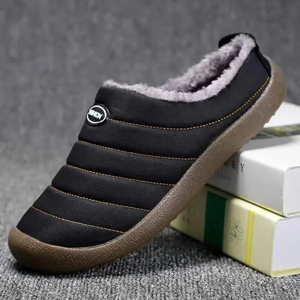 Close-up side shot of black quilted slippers highlighting the ribbed stitching detail
