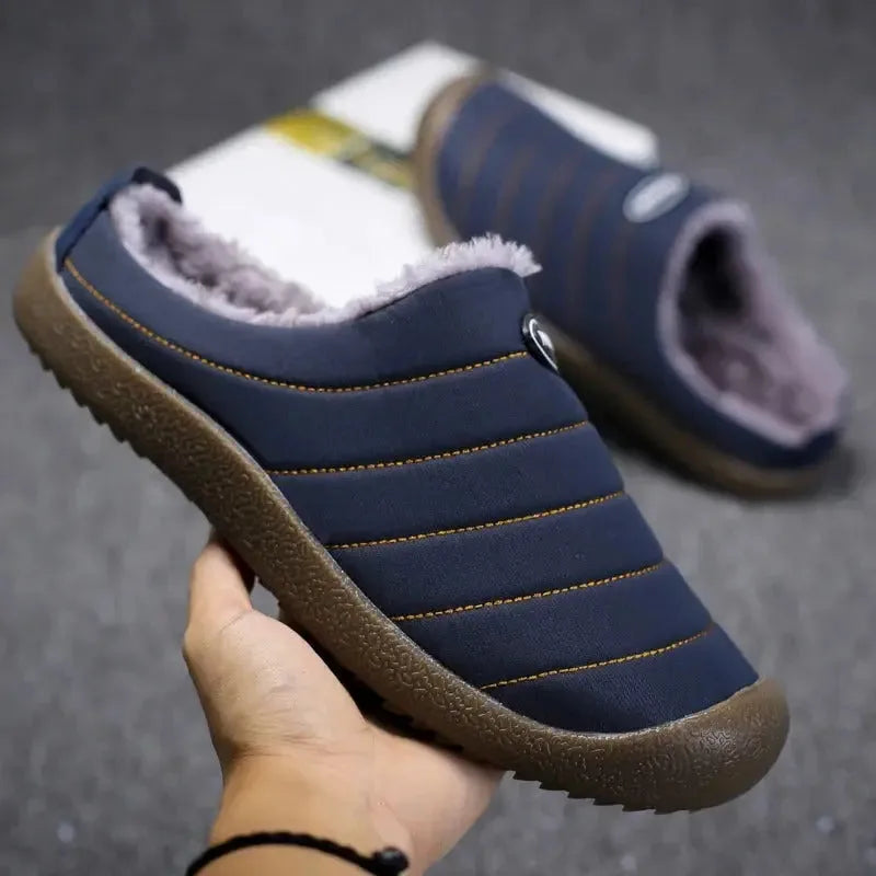 Close-up angled view of navy slippers stacked together showing the plush inner lining
