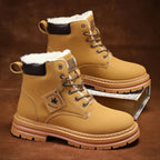 Pair of tan boots with fur-lined collar standing on a wooden surface near rope coils