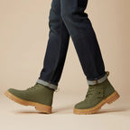 Man walking in khaki green lace-up boots paired with dark denim turn-ups
