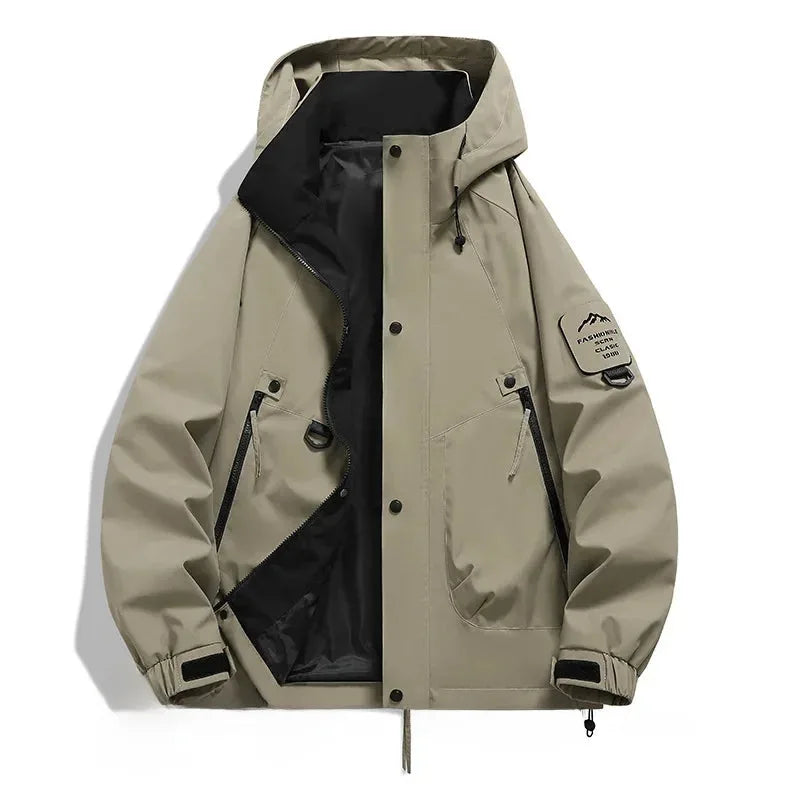 Khaki beige hooded jacket laid flat, open front with black lining, zip pockets and mountain patch on right sleeve