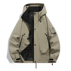 Khaki beige hooded jacket laid flat, open front with black lining, zip pockets and mountain patch on right sleeve