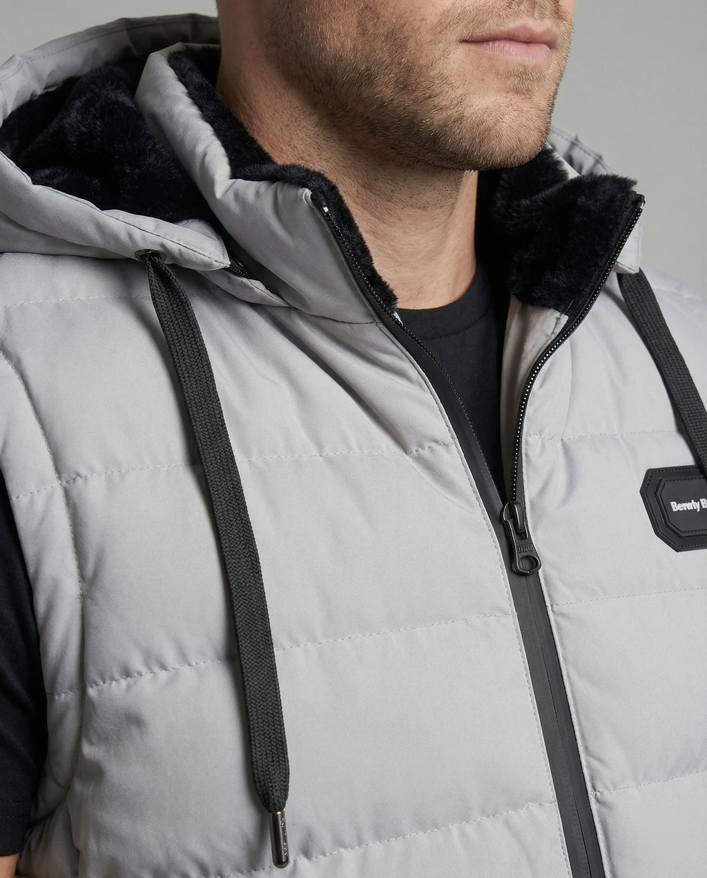 Close-up of the grey gilet's hood with black faux fur trim, adjustable drawcords and zip-through neck