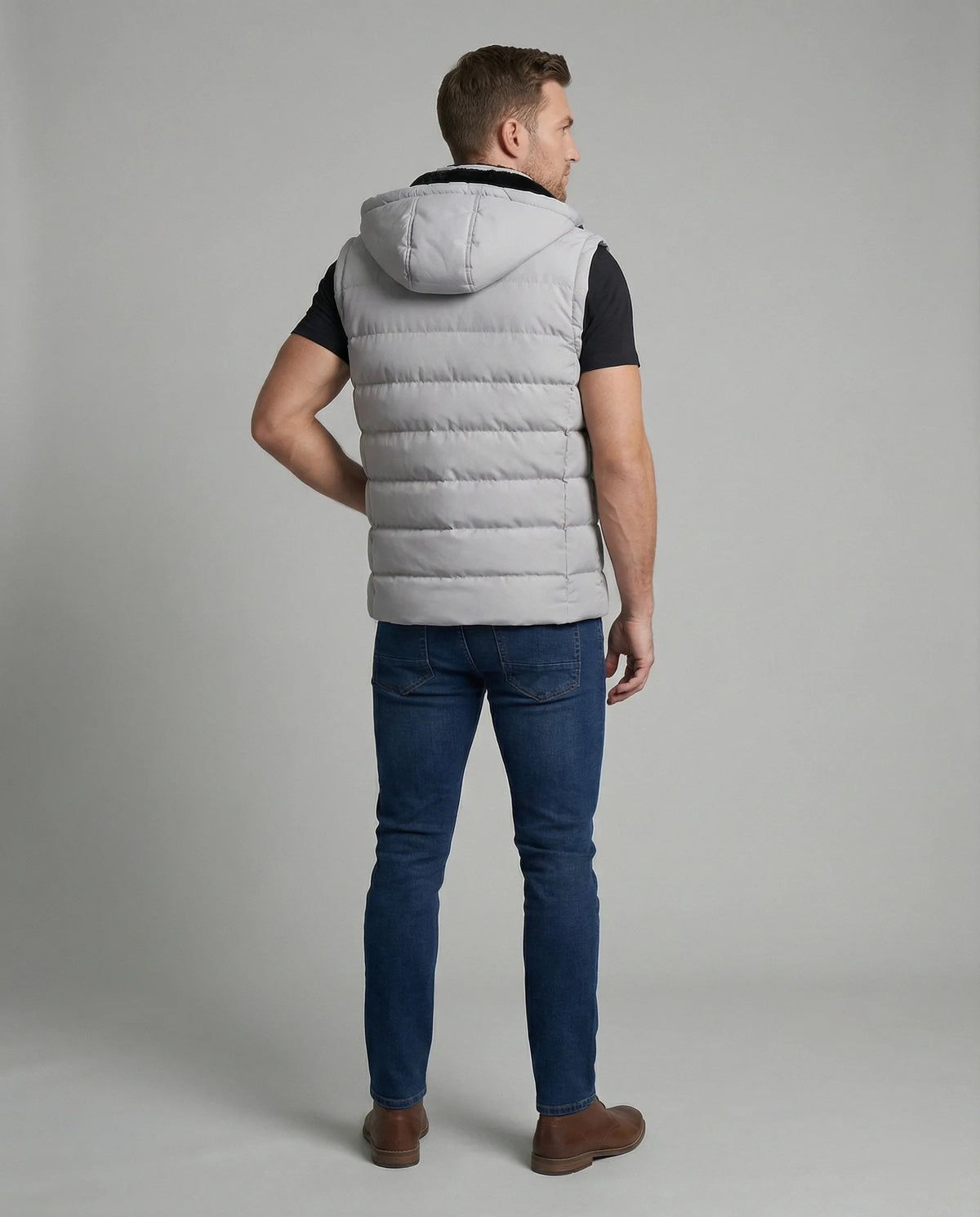 Back view of a man wearing the grey quilted hooded gilet, showing horizontal channel stitching across the shoulders