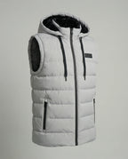 Product shot of a light grey hooded gilet with faux fur lined hood, zip pockets and branded chest patch