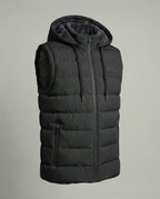 Product shot of a black quilted hooded gilet with contrast grey faux fur lined hood and zip front