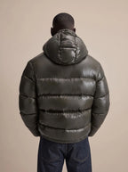 Side angle close-up of the quilted shoulder and sleeve detail on the glossy puffer jacket
