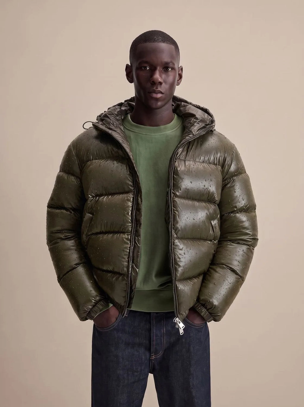 Close-up front view of the olive puffer jacket showing water droplets beading on the high-shine quilted fabric