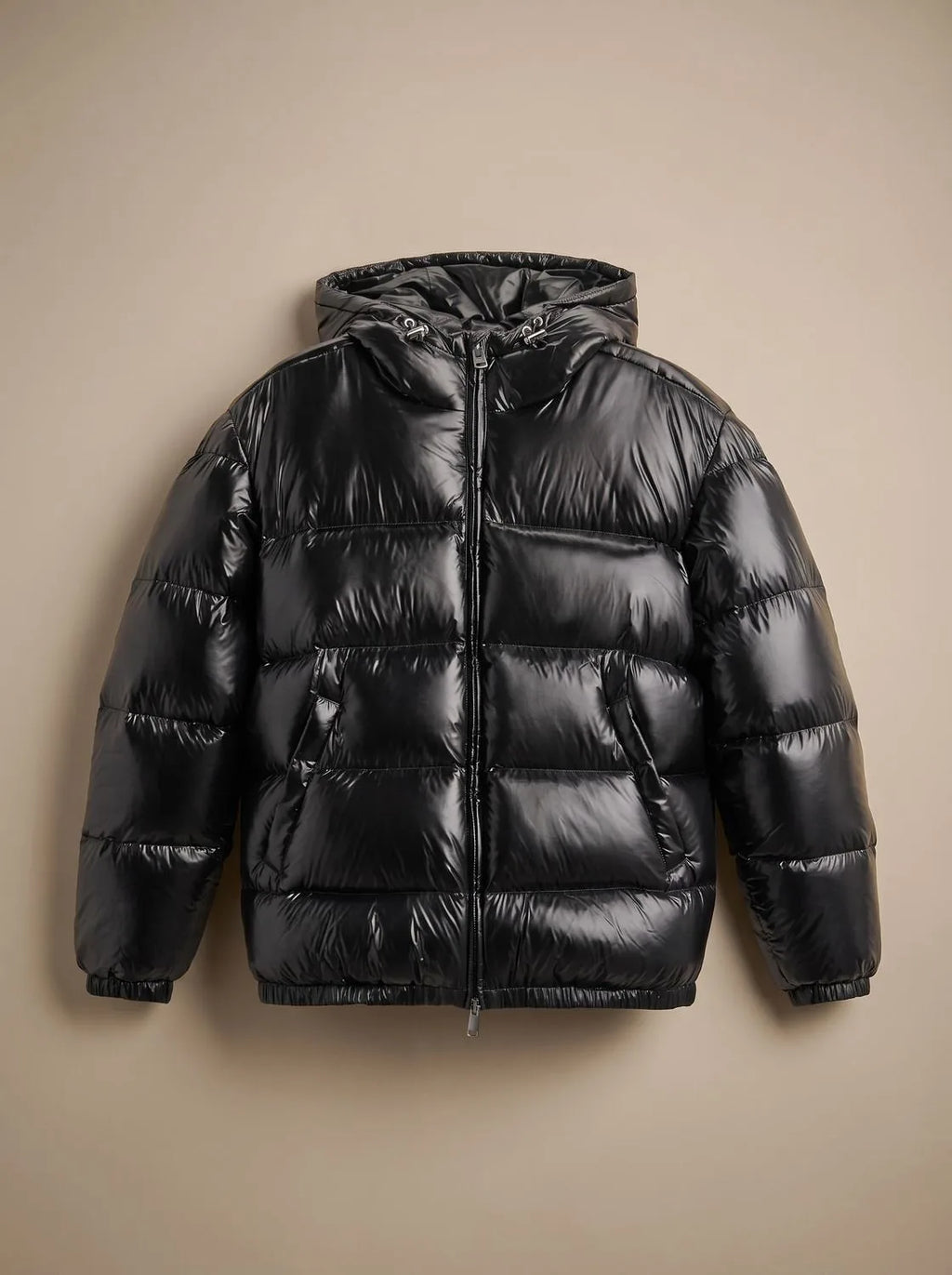 Flat lay of a glossy black hooded puffer jacket with centre zip and twin front pockets