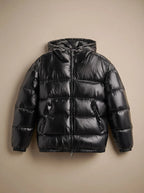 Flat lay of a glossy black hooded puffer jacket with centre zip and twin front pockets