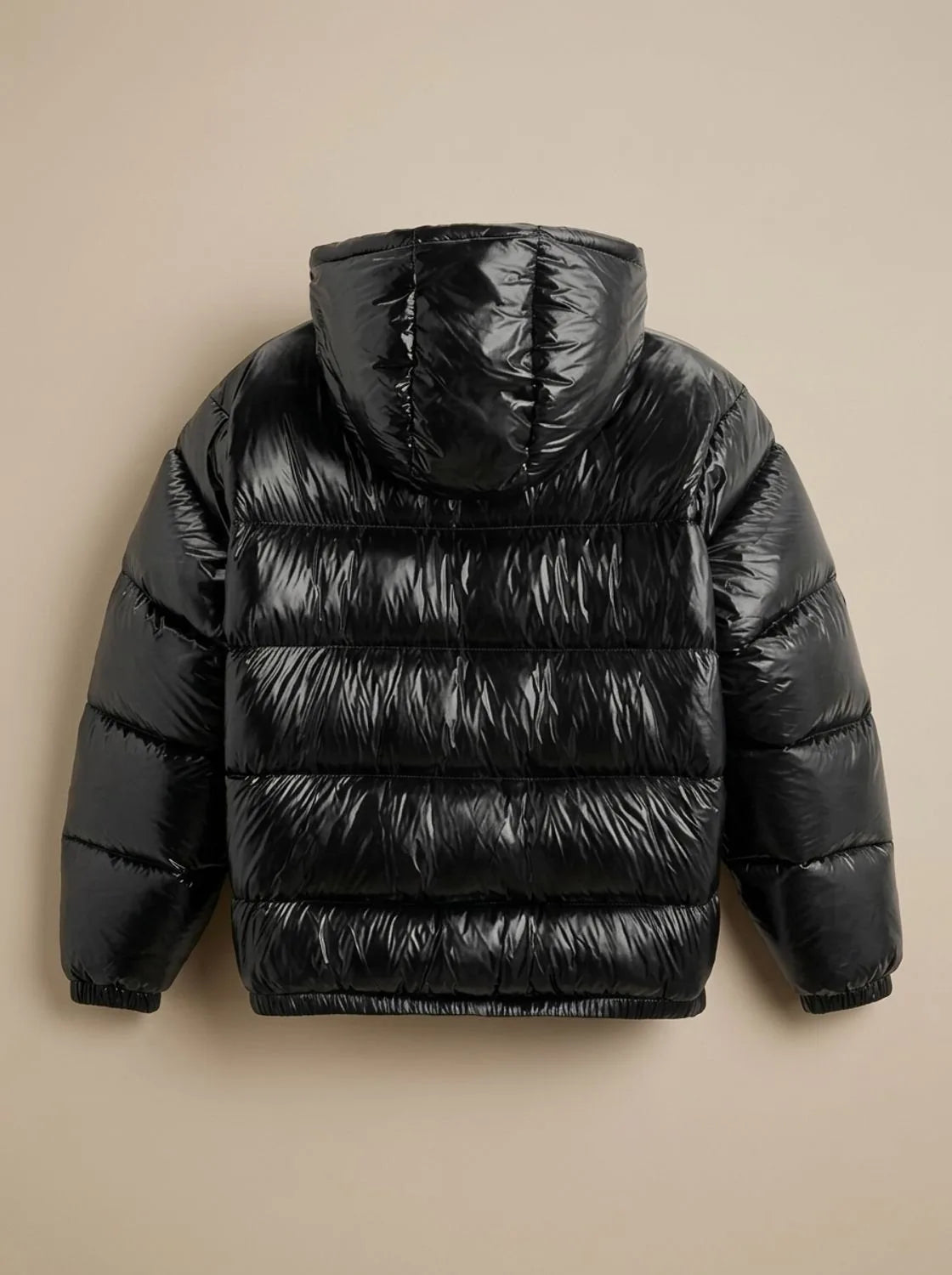 Back view flat lay of the black puffer jacket showing the attached hood and horizontal quilted channels
