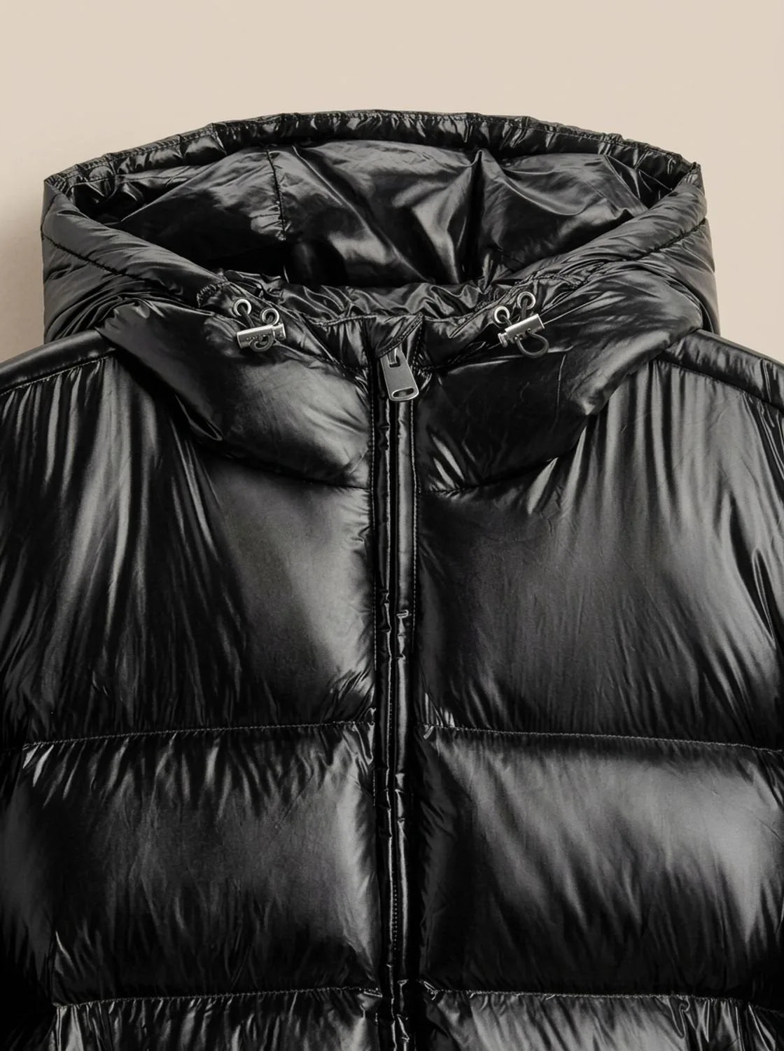 Close-up of the black jacket's hood and collar area showing the zip pull and adjustable hood toggles