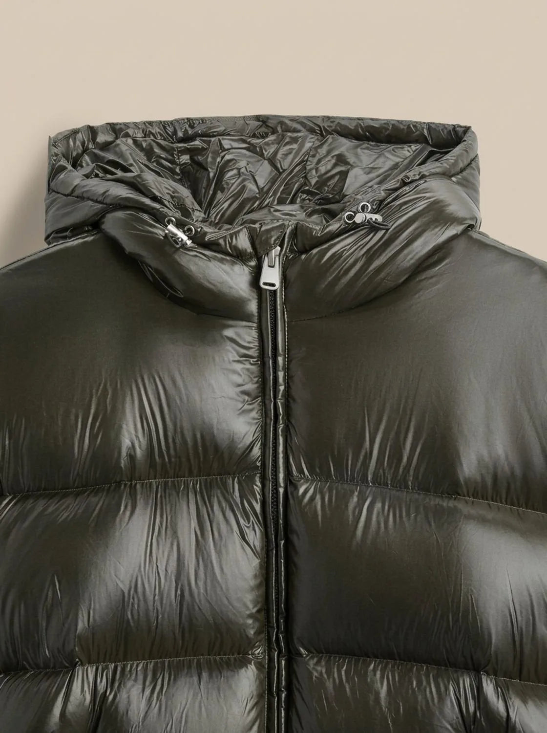 Front view of the black puffer jacket laid flat highlighting the glossy nylon-look shell texture