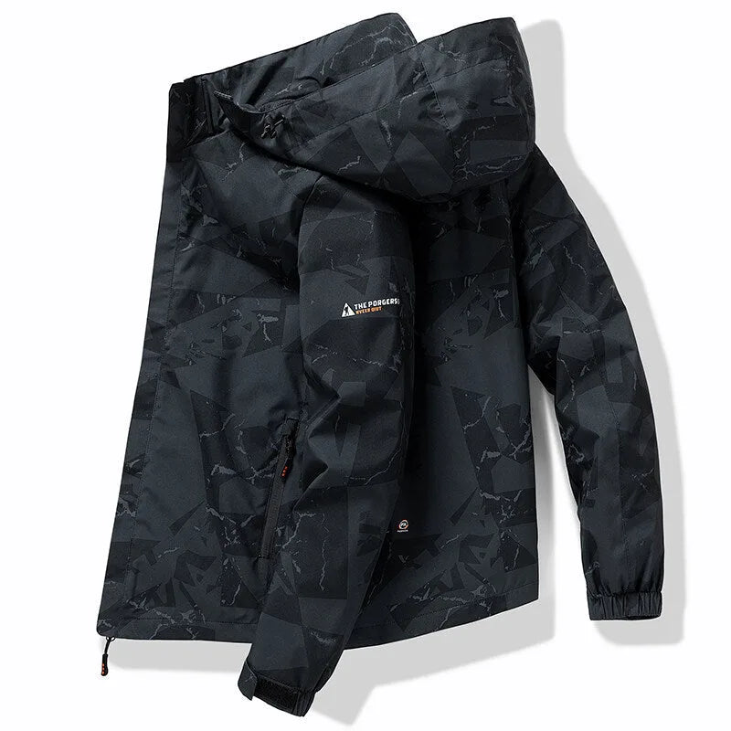 Black camouflage-print hooded jacket folded flat, showing geometric pattern and zip chest pocket detail