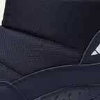 Detail shot of the quilted ankle cuff, textured panel and reflective side logo on a black snow boot