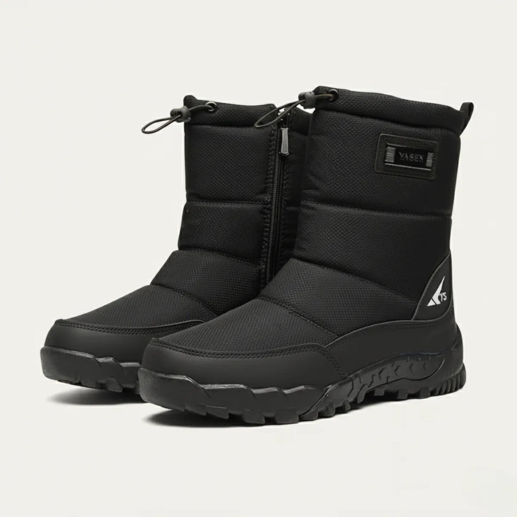 Three-quarter view of a pair of black padded snow boots with branded tab and chunky tread sole