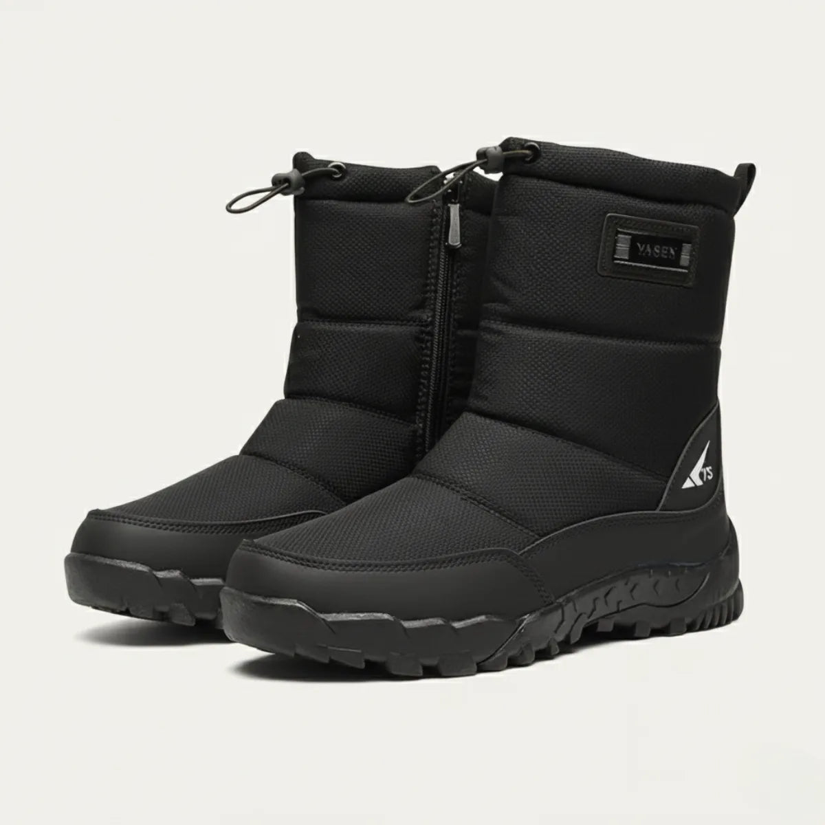 Three-quarter view of a pair of black padded snow boots with branded tab and chunky tread sole