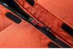 Front view of the black parka on a flat surface, showing the drawstring hood and zipped vertical pockets