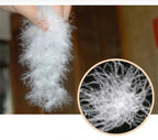Close-up of soft white down fill held in hand, showing the fluffy insulation fibres used inside the parka