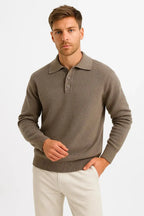 Front view of man wearing a coffee brown knit polo jumper with structured collar and three-button placket, paired with cream trousers