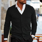 Black knitted cardigan with front pockets and button fastening worn with black trousers