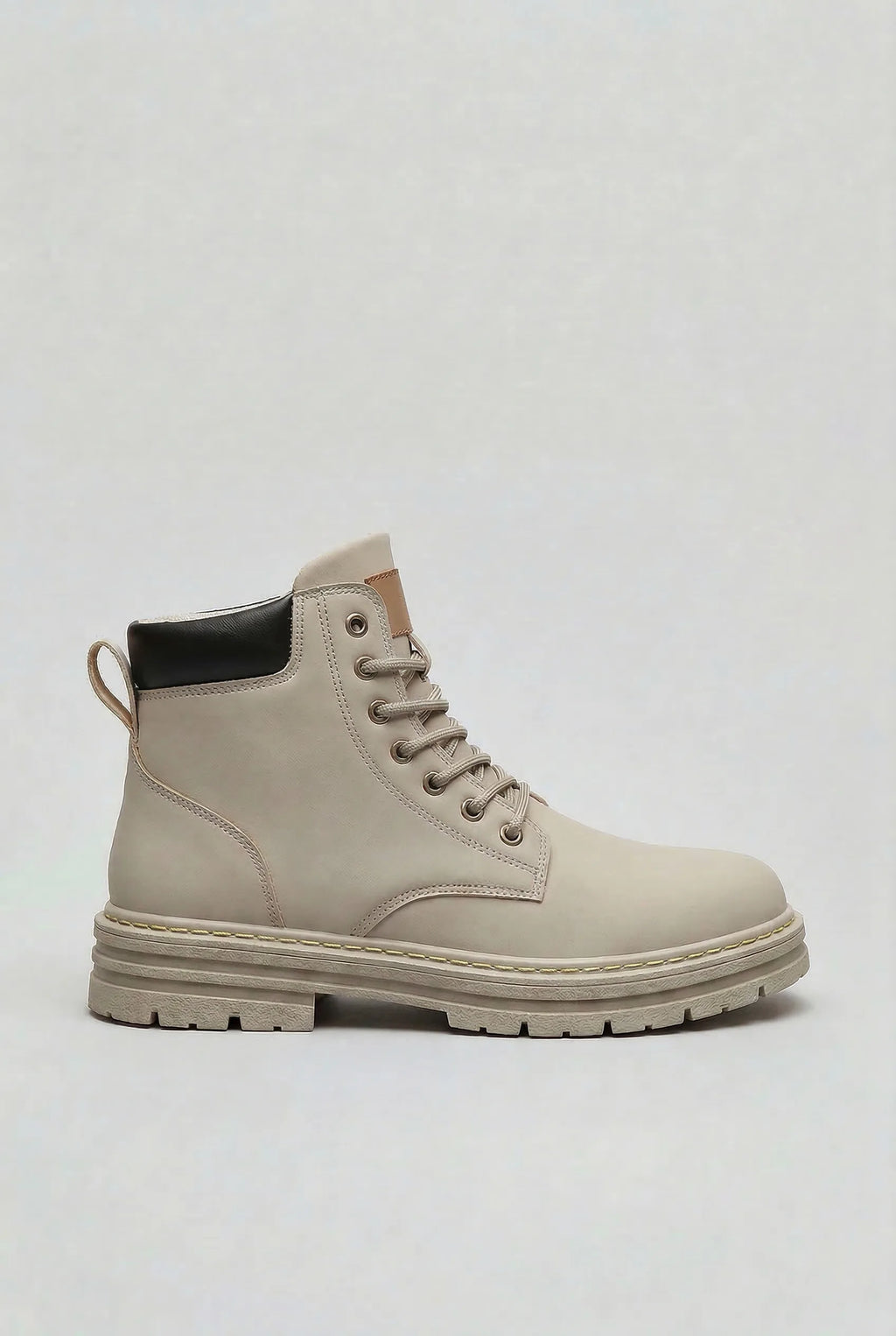 Side profile of a light grey lace-up ankle boot with a black heel panel and chunky lugged sole