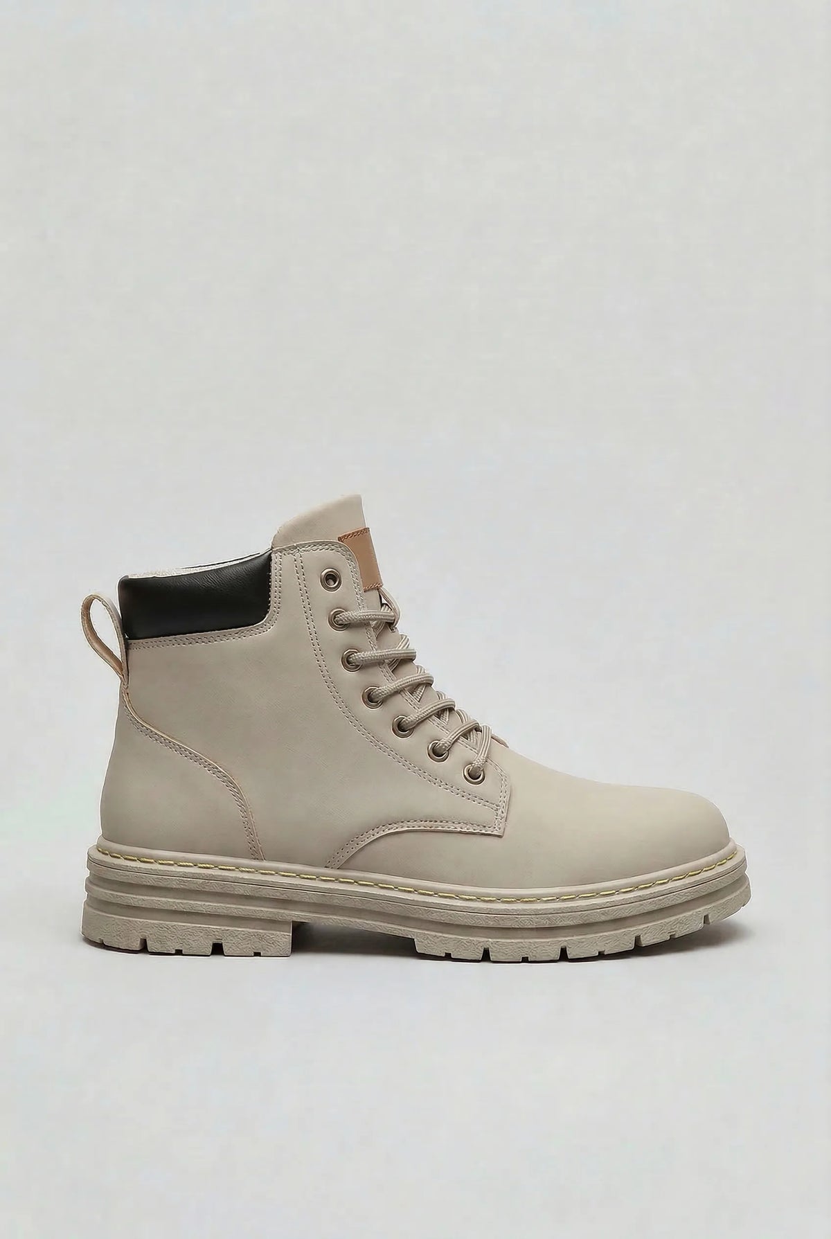 Side profile of a light grey lace-up ankle boot with a black heel panel and chunky lugged sole