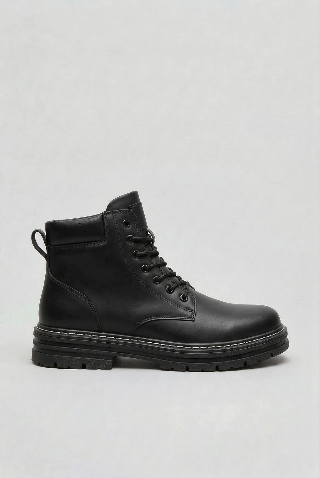 Side view of a black lace-up ankle boot with a thick ridged lug sole and contrast stitching