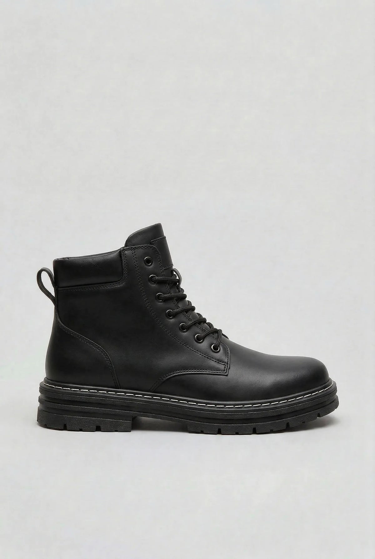 Side view of a black lace-up ankle boot with a thick ridged lug sole and contrast stitching