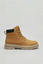 Side view of a tan lace-up ankle boot with yellow laces, black heel trim and a stacked cream sole