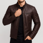 Brown leather motorcycle jacket with stand collar and quilted shoulder stitching, worn open over a black t-shirt