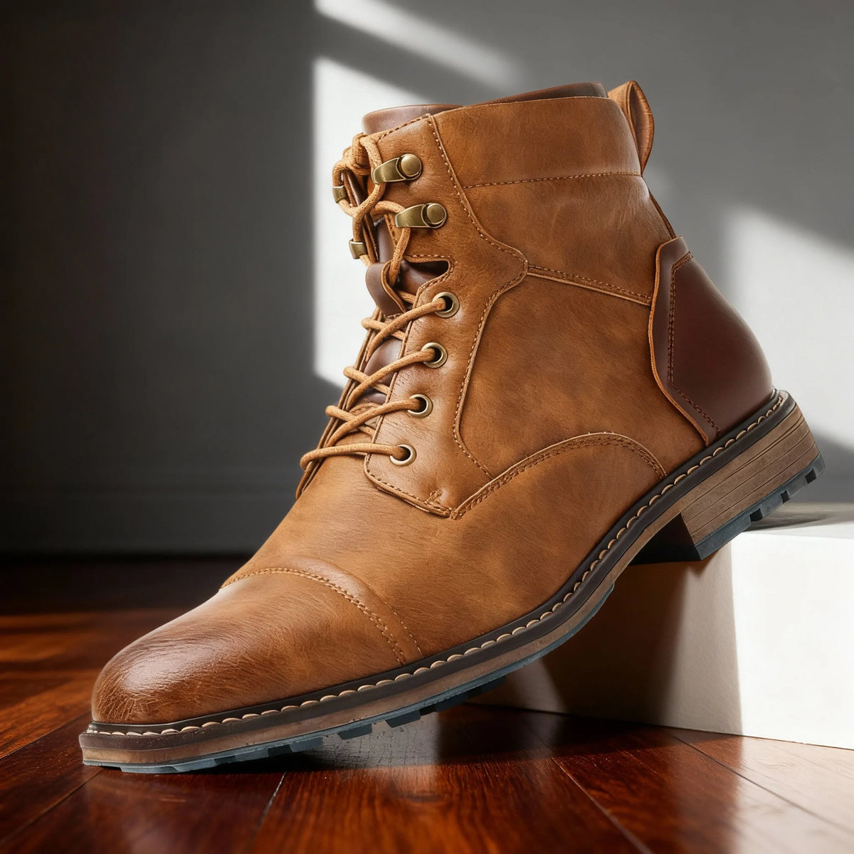Front-angle view of oak tan leather combat boot with bronze hardware and cap-toe stitching