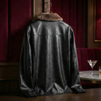 Back view of black shearling-collar leather jacket on a hanger, showing clean panel seams and smooth finish