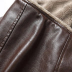 Close-up of brown leather collar edge against soft fleece lining, highlighting the shearling trim and seam